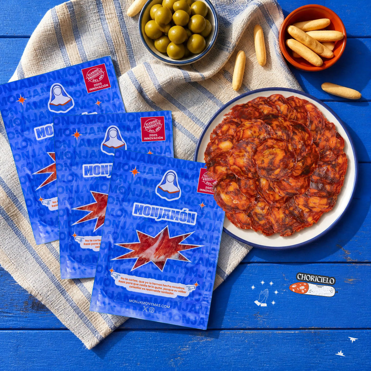 Choricielo Loncheado · Chorizo 100% ibérico de bellota · 10 sobres de 50 g – vista desde arriba: tres sobres de Choricielo junto a un plato lleno de chorizo loncheado