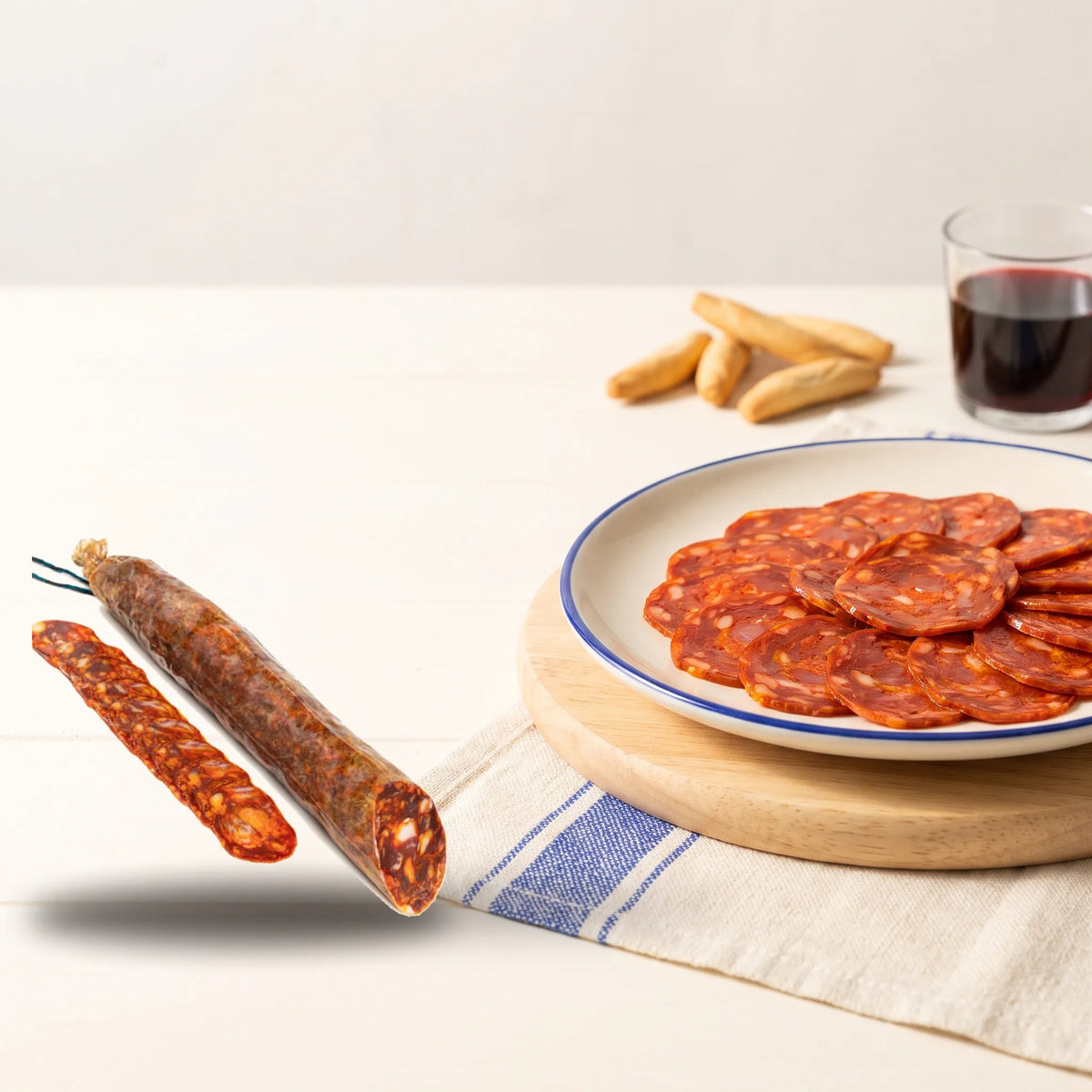 Choricielo · Chorizo 100% ibérico de bellota · Media pieza 450-500 g – la pieza junto a un plato de Choricielo recién cortado