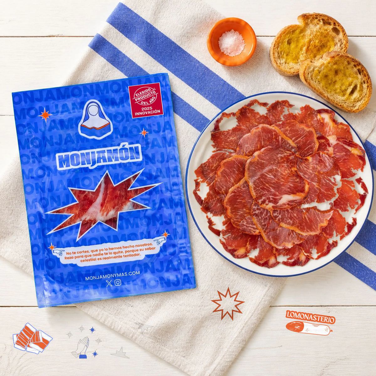 Sobre 50gr Lomonasterio · Lomo de Bellota 100% Ibérico – vista desde arriba: una ración de Lomonasterio loncheado en un plato pequeño, con el sobre al lado