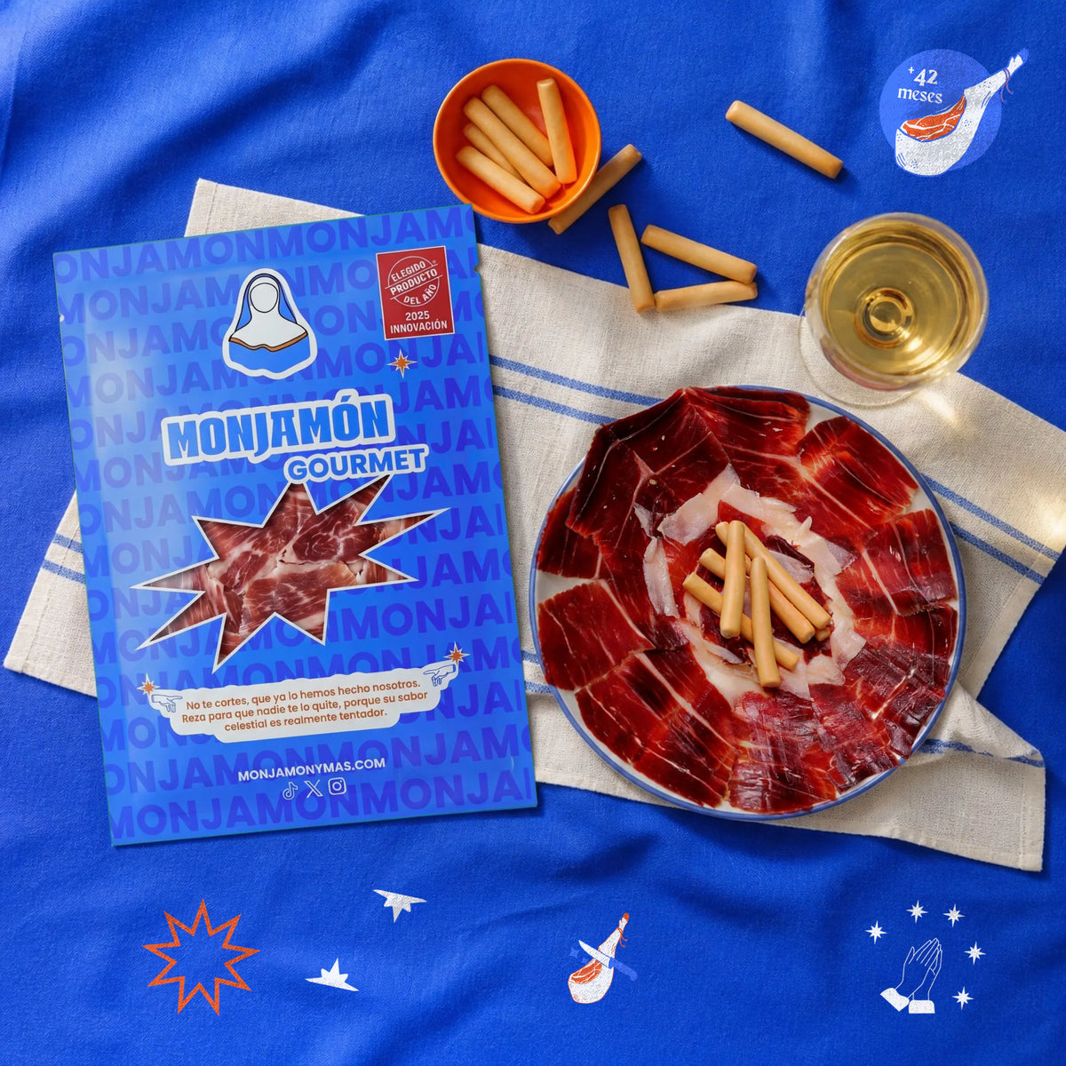 Sobre 80gr Jamón de Bellota 100% Ibérico +42 Meses · a Cuchillo – vista desde arriba: una ración de jamón cortado a cuchillo en un plato pequeño, con el sobre al lado